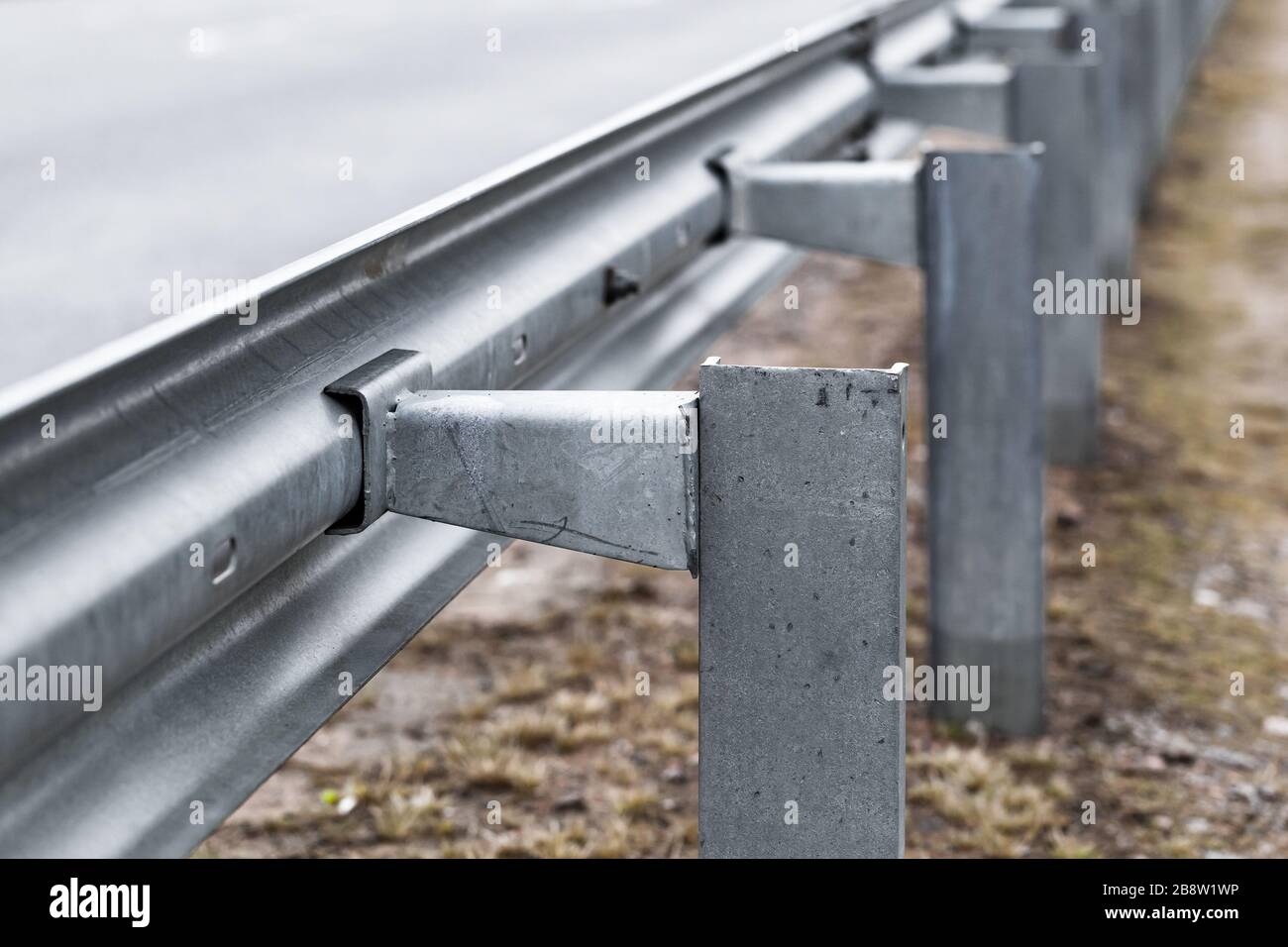 metal-guardrail-construction-mounted-on-a-highway-roadside-2B8W1WP.jpg